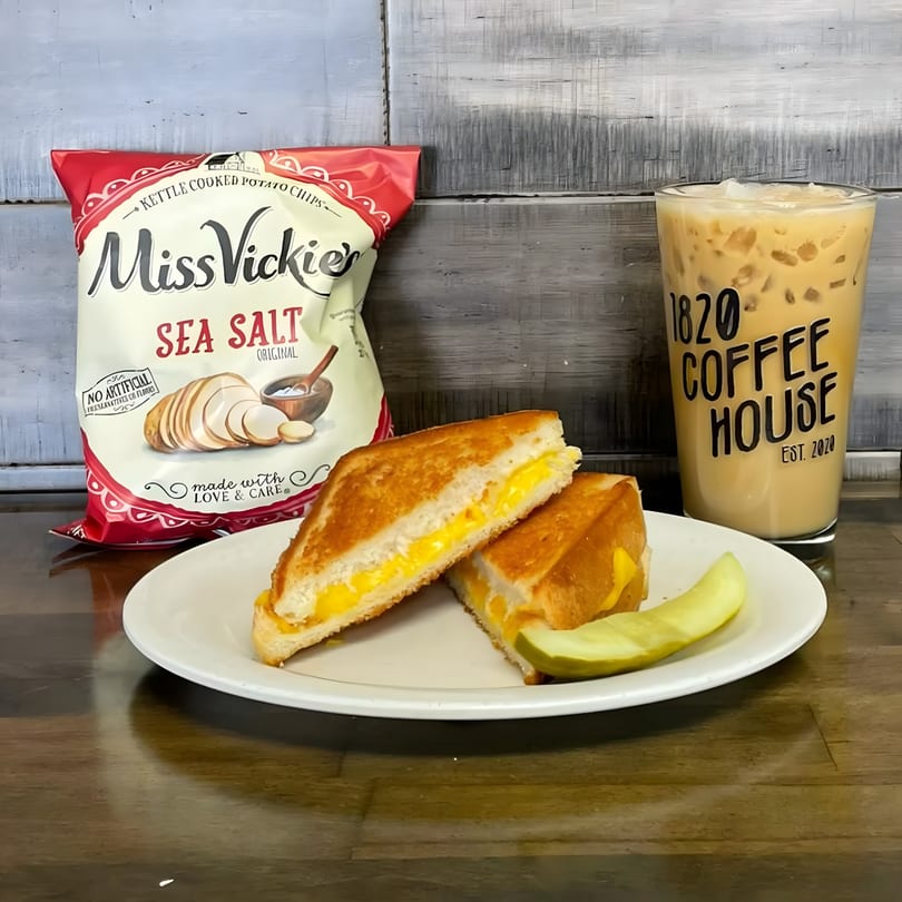 Grilled cheese sandwich with a pickle, Miss Vickie's chips, and an iced coffee from 1820 Coffee House.